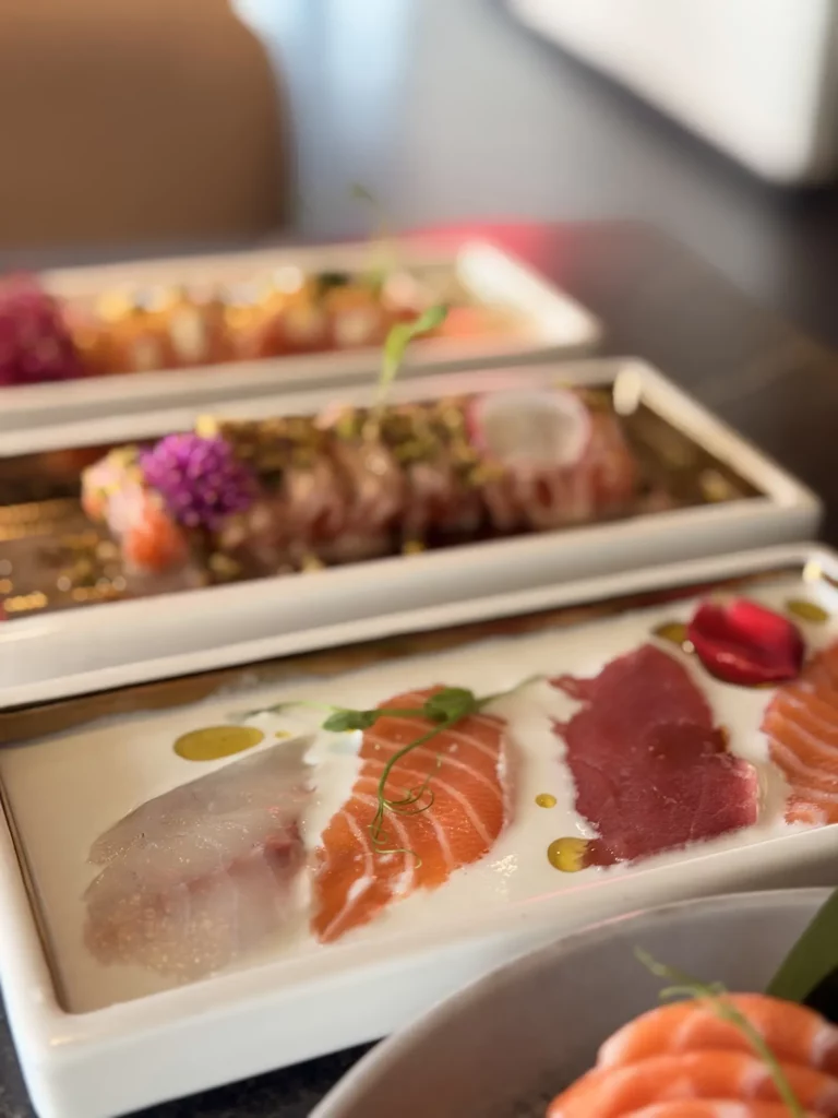 Tataki e carpacci di pesce su piatti bianchi