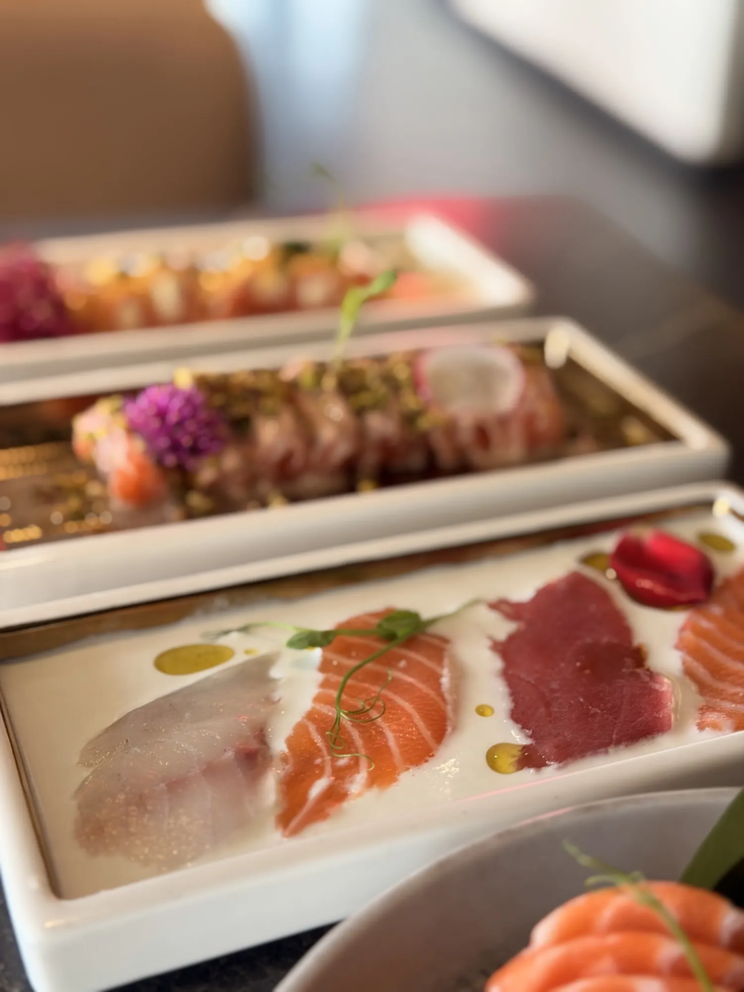 Tataki e carpacci di pesce fresco su piatti bianchi