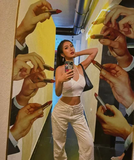 Ragazza in posa davanti alla parete decorata con le mani disegnate